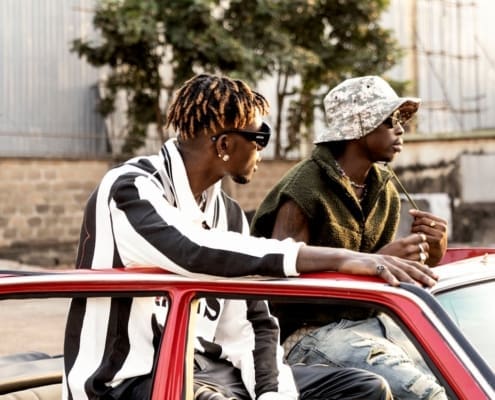Stylish young men in Lagos, Nigeria, enjoying an urban setting in fashionable attire.