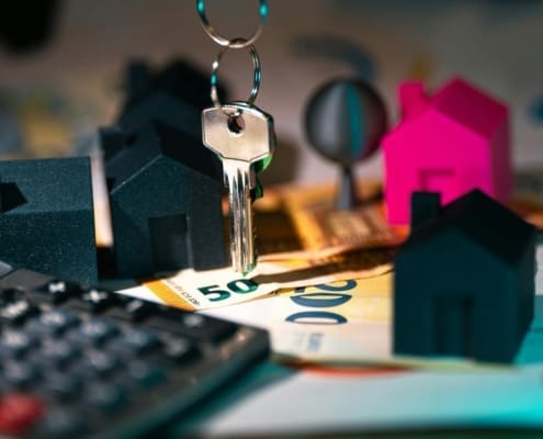A symbolic representation of real estate finance featuring keys, model houses, and euro banknotes.