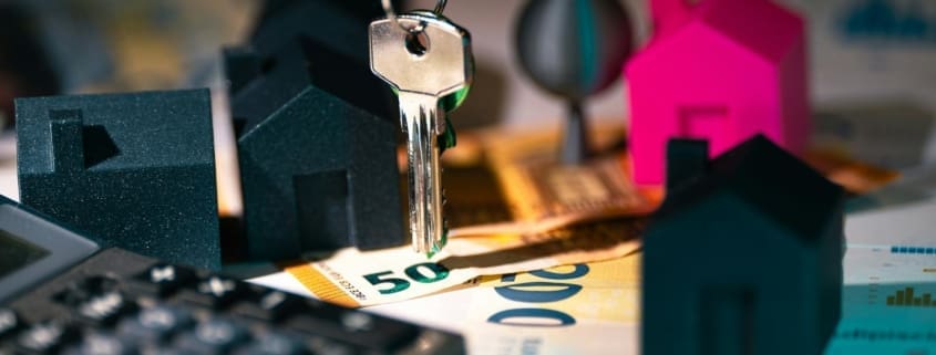 A symbolic representation of real estate finance featuring keys, model houses, and euro banknotes.