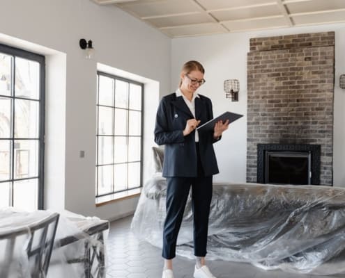 Real estate agent in a suit reviewing paperwork inside a newly renovated home.