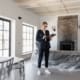 Real estate agent in a suit reviewing paperwork inside a newly renovated home.
