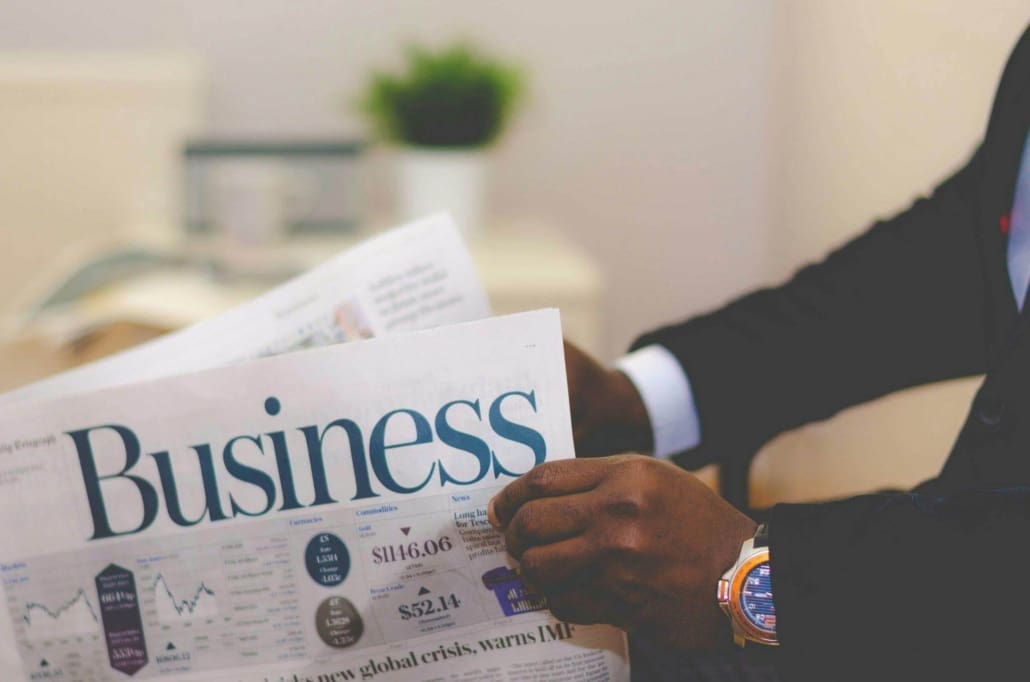Business Interests Commonly Requiring CGT Valuations A person in a suit reads a newspaper with the headline "Business." Only their hands and part of their suit are visible, and there are charts, text, and articles on Business Interest CGT Valuations on the newspaper’s front page.