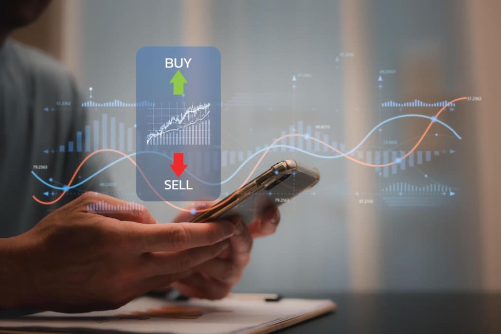 Share Valuations Sydney, A person using a smartphone with holographic buy and sell buttons, stock charts, and graphs overlayed, representing online trading or tracking Share Valuations Sydney.